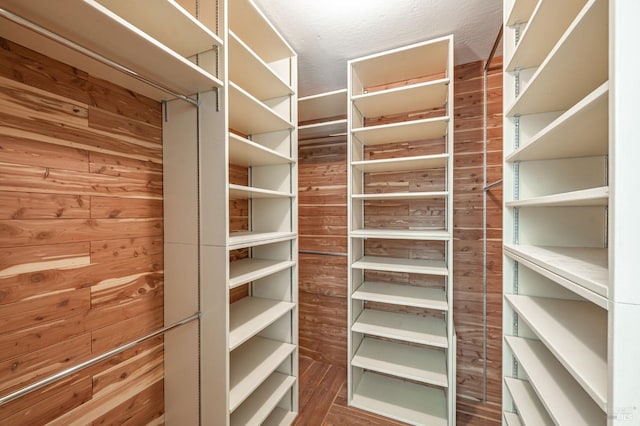 walk in closet with wood finished floors