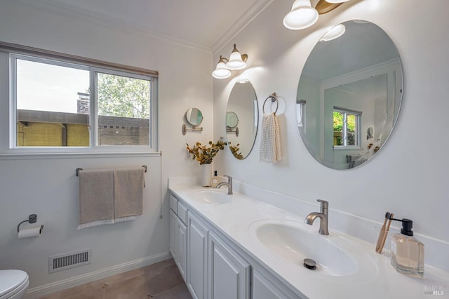 full bath featuring a sink, double vanity, toilet, visible vents, and ornamental molding