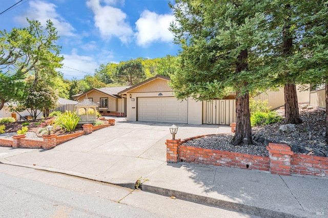 view of front of house featuring concrete driveway, an attached garage, and fence