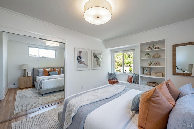bedroom with crown molding, baseboards, and wood finished floors