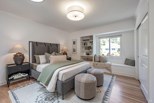 bedroom featuring baseboards, ornamental molding, a closet, and wood finished floors