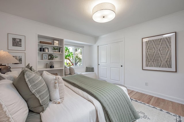bedroom with baseboards, ornamental molding, and light wood-style flooring