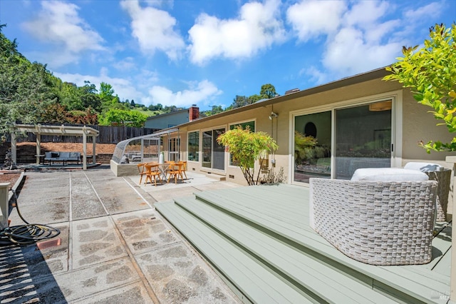 deck featuring a patio, fence, outdoor dining space, and a pergola