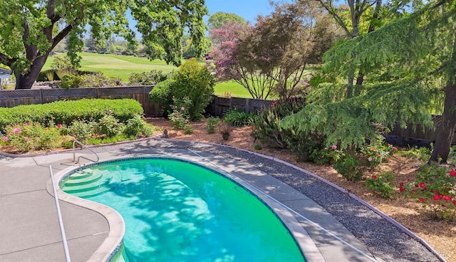 view of pool with view of golf course and a fenced backyard