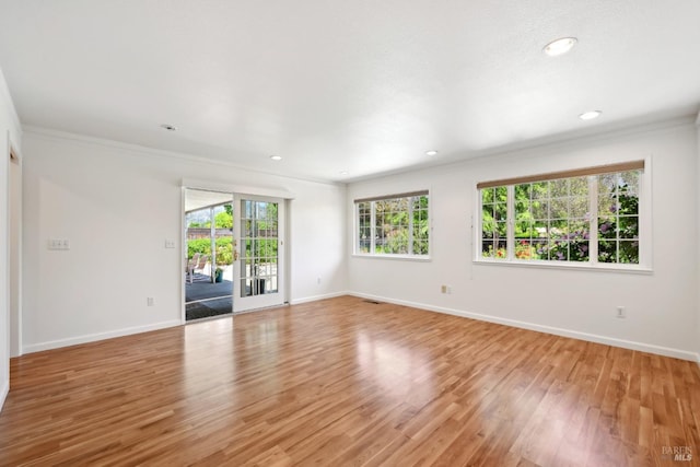 empty room featuring light wood-style flooring, recessed lighting, baseboards, visible vents, and ornamental molding
