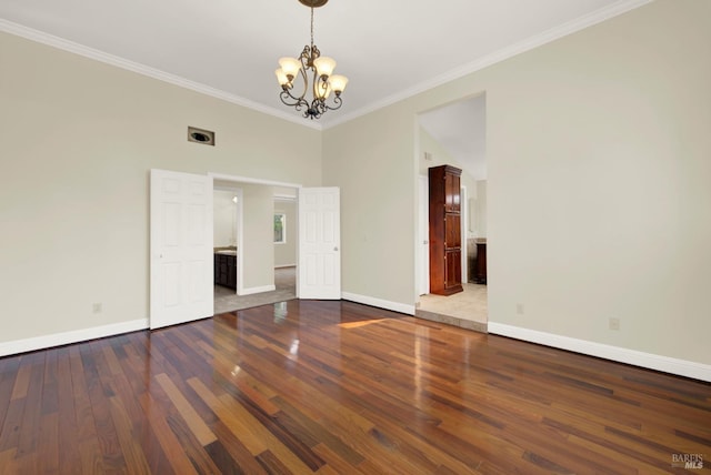 unfurnished room with baseboards, a notable chandelier, ornamental molding, and hardwood / wood-style floors
