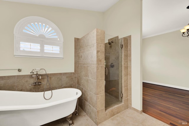 bathroom featuring a freestanding tub, a shower stall, and tile patterned floors