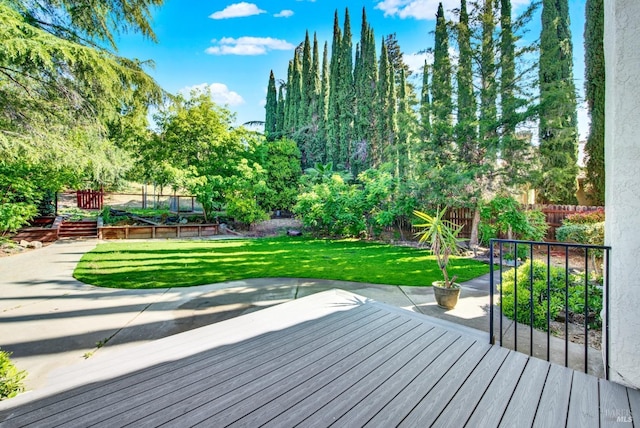 wooden deck featuring a fenced backyard, a patio, and a yard