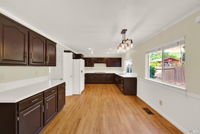 kitchen featuring freestanding refrigerator, visible vents, light wood finished floors, and light countertops