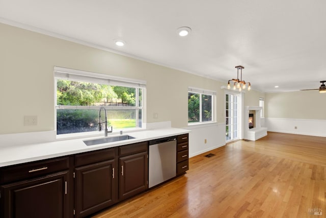 kitchen featuring light countertops, a wealth of natural light, a sink, and dishwasher