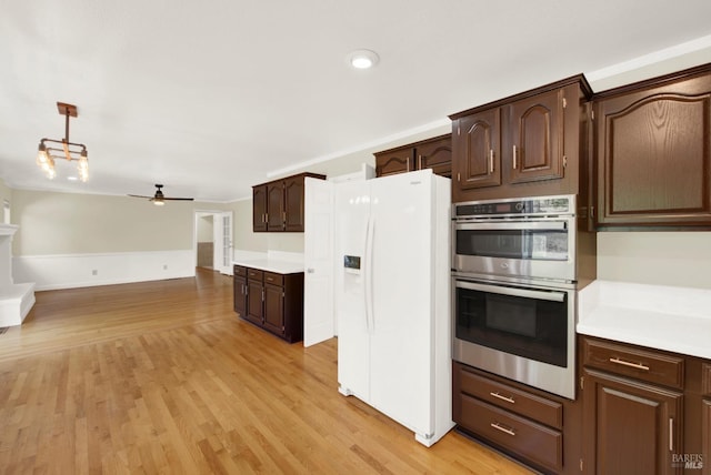 kitchen featuring ceiling fan, dark brown cabinets, light countertops, double oven, and white fridge with ice dispenser