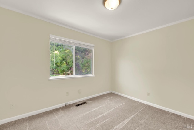 carpeted empty room featuring crown molding, baseboards, and visible vents