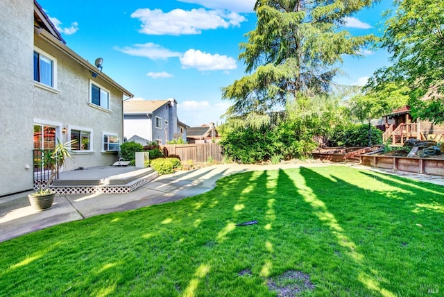 view of yard featuring fence, a patio, a deck, and a residential view
