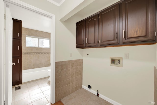 clothes washing area with cabinet space, hookup for a washing machine, gas dryer hookup, electric dryer hookup, and light tile patterned floors