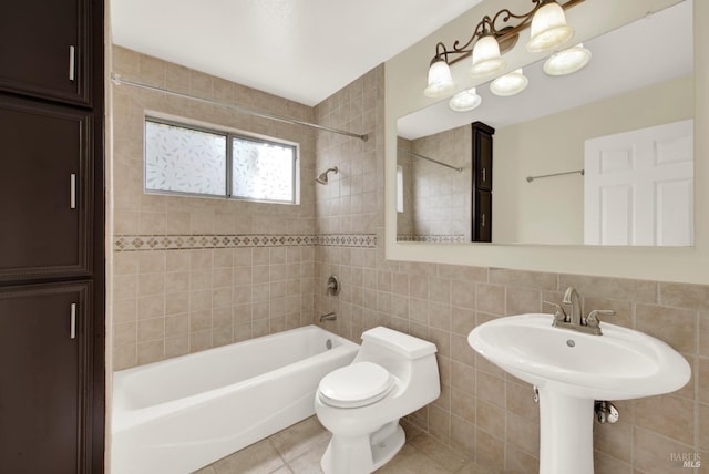 bathroom with shower / bath combination, tile patterned floors, toilet, and tile walls