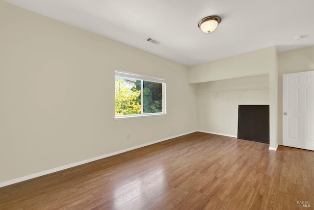 empty room with visible vents, baseboards, and wood finished floors