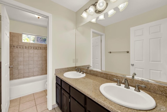 full bathroom featuring double vanity, toilet, a sink, and tile patterned flooring