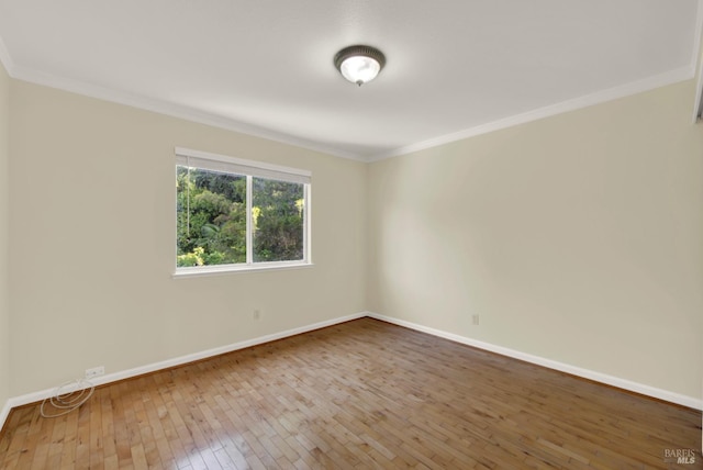 unfurnished room with crown molding, baseboards, and wood-type flooring