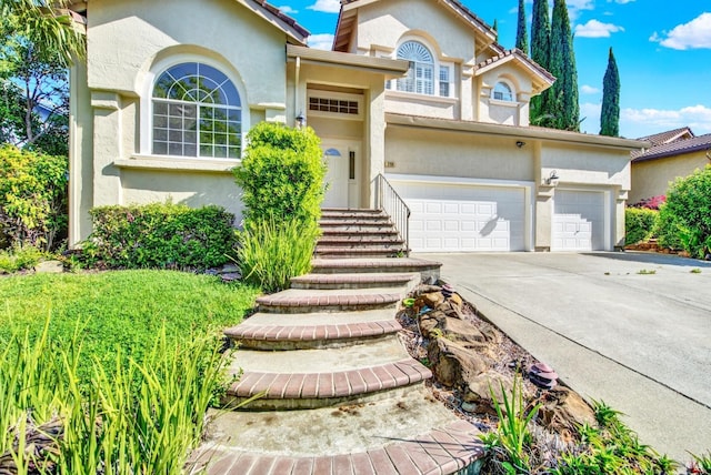 view of front of home featuring a garage, stucco siding, and driveway