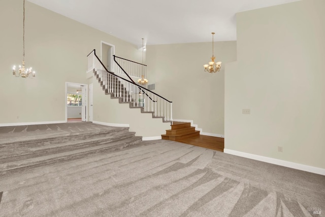 unfurnished living room featuring an inviting chandelier, stairway, and carpet
