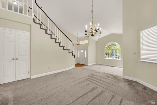 carpeted entryway featuring an inviting chandelier, baseboards, stairs, and lofted ceiling