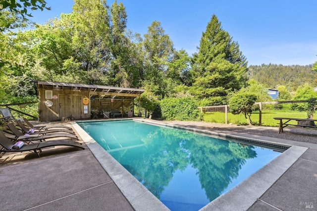 outdoor pool with fence and a patio area