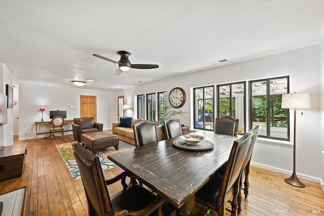 dining room with visible vents, a ceiling fan, light wood finished floors, and baseboards