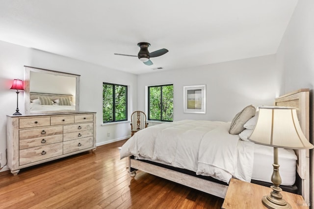 bedroom featuring baseboards, ceiling fan, hardwood / wood-style floors, and visible vents