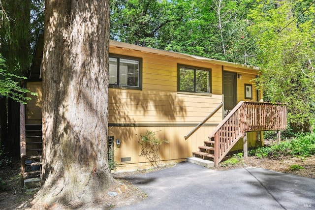 view of front of home with a patio, crawl space, and stairs