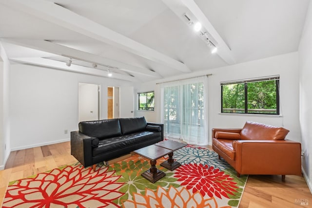 living room with baseboards, vaulted ceiling with beams, rail lighting, and wood finished floors