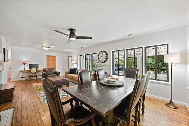 dining area featuring baseboards, ceiling fan, light wood-style flooring, and visible vents