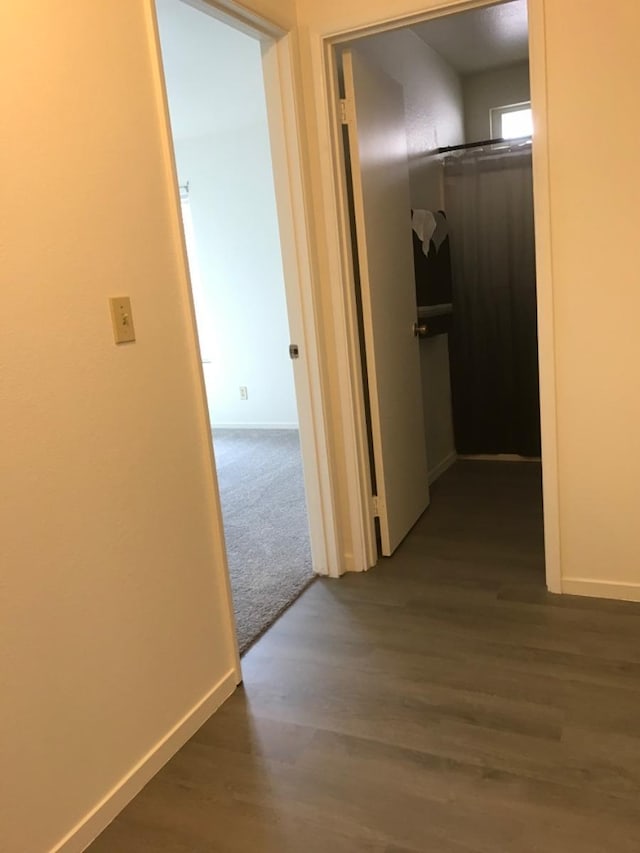 hall with baseboards and dark wood-style floors