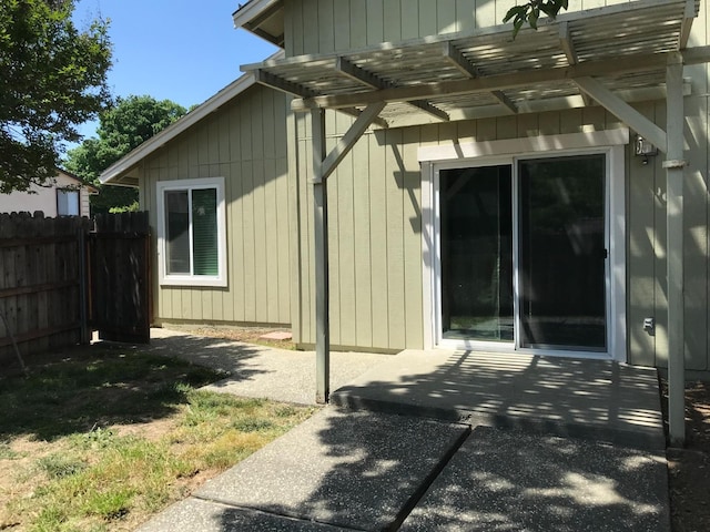 view of home's exterior featuring fence, a pergola, and a patio
