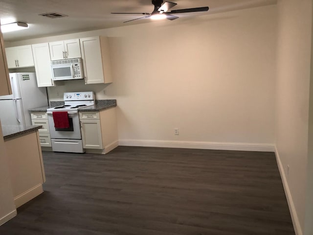 kitchen with visible vents, white appliances, baseboards, ceiling fan, and dark wood finished floors
