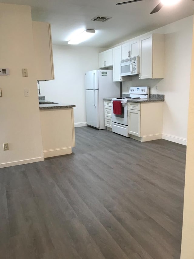 kitchen with a ceiling fan, visible vents, baseboards, white appliances, and dark wood-type flooring