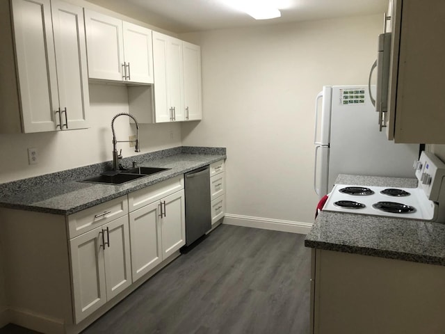 kitchen featuring white cabinets, a sink, white appliances, dark wood finished floors, and baseboards