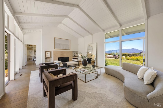 living area with beamed ceiling, hardwood / wood-style floors, high vaulted ceiling, and a mountain view