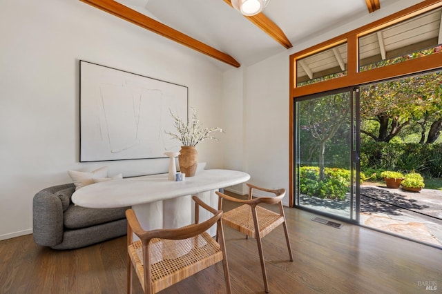 dining room with baseboards, vaulted ceiling with beams, wood finished floors, and visible vents