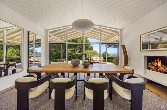 sunroom featuring a wealth of natural light and a warm lit fireplace