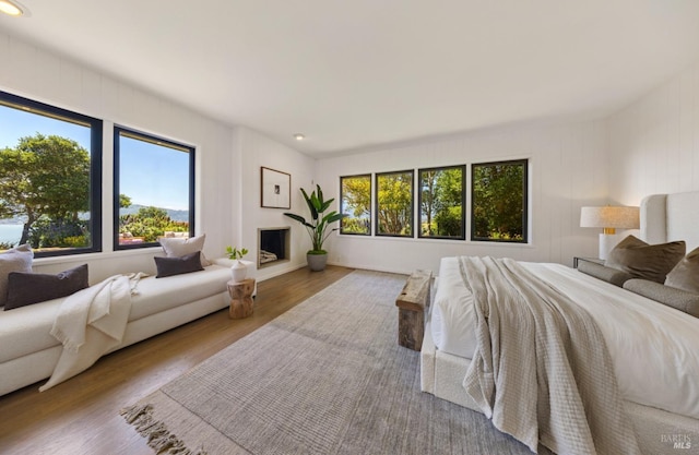 bedroom with a fireplace, recessed lighting, and wood finished floors