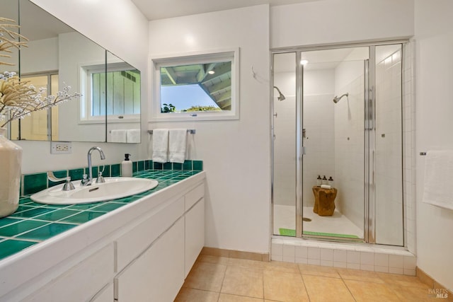 full bath featuring tile patterned flooring, baseboards, a shower stall, and vanity