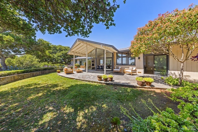 rear view of property with a yard, a patio area, a sunroom, and an outdoor living space