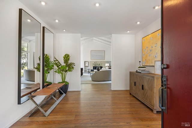 hall featuring baseboards, recessed lighting, and hardwood / wood-style flooring