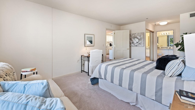 bedroom with carpet floors, connected bathroom, baseboards, and visible vents