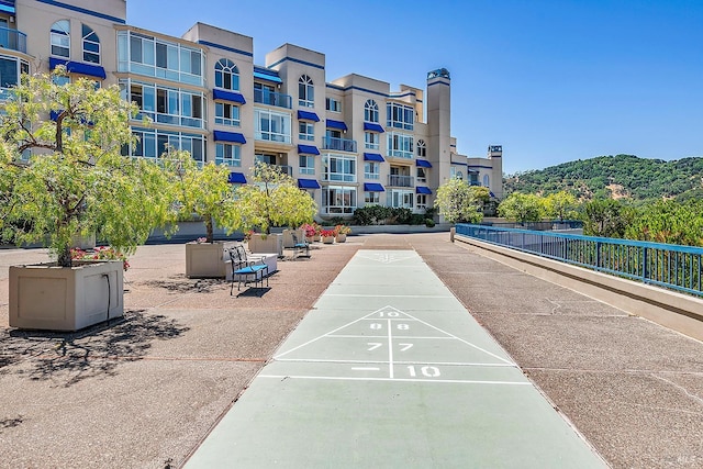 view of home's community featuring shuffleboard and fence