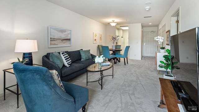 living room with baseboards, visible vents, and light carpet