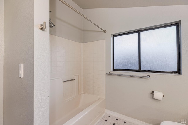 full bathroom with toilet, baseboards, and tub / shower combination