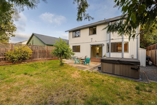 rear view of house featuring a hot tub, a lawn, a fenced backyard, and a patio area