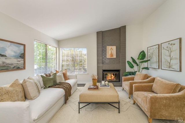 living room featuring light wood-style floors, vaulted ceiling, and a fireplace