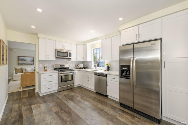 kitchen featuring light countertops, appliances with stainless steel finishes, white cabinets, and tasteful backsplash